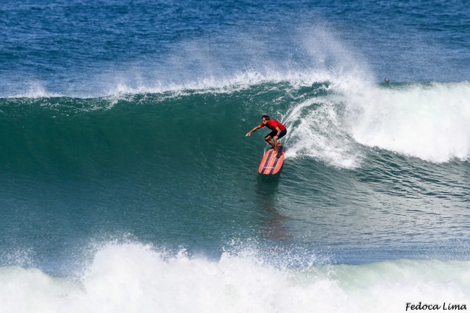 homem de vermelho surfando